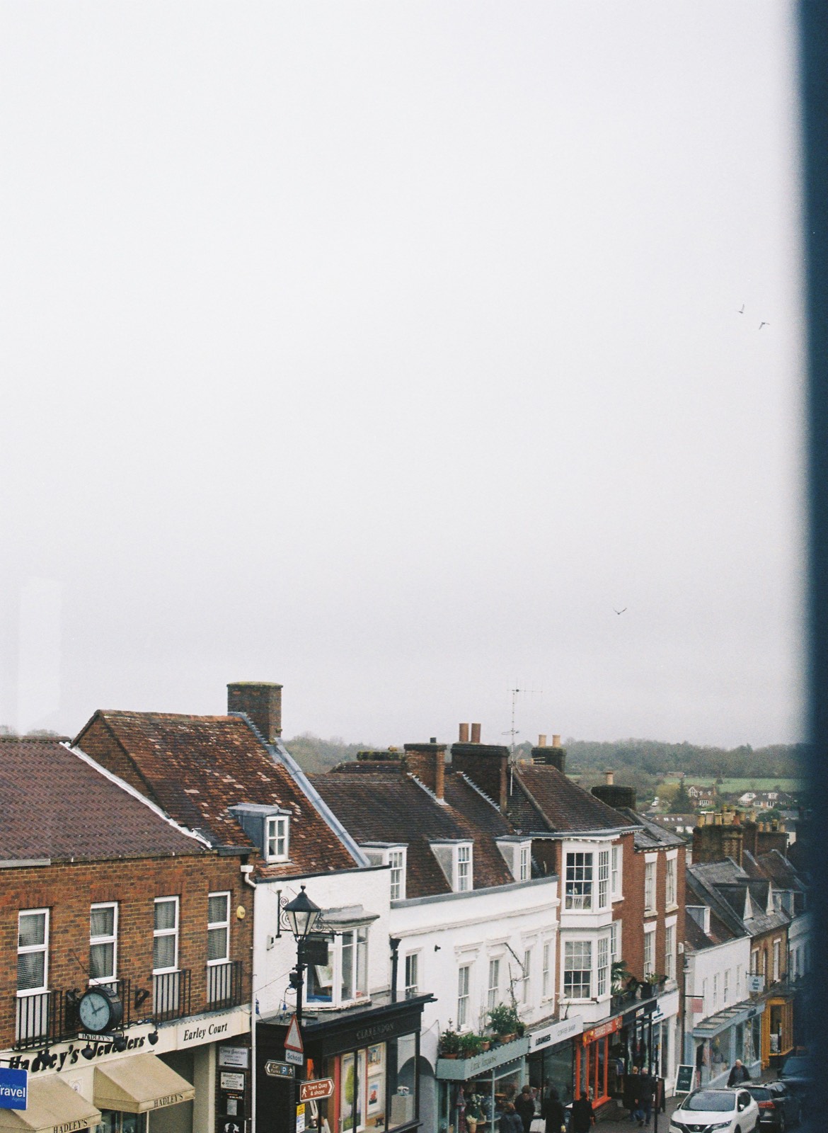 A row of British high street shops, pubs and restaurants seen from above on an overcast day.